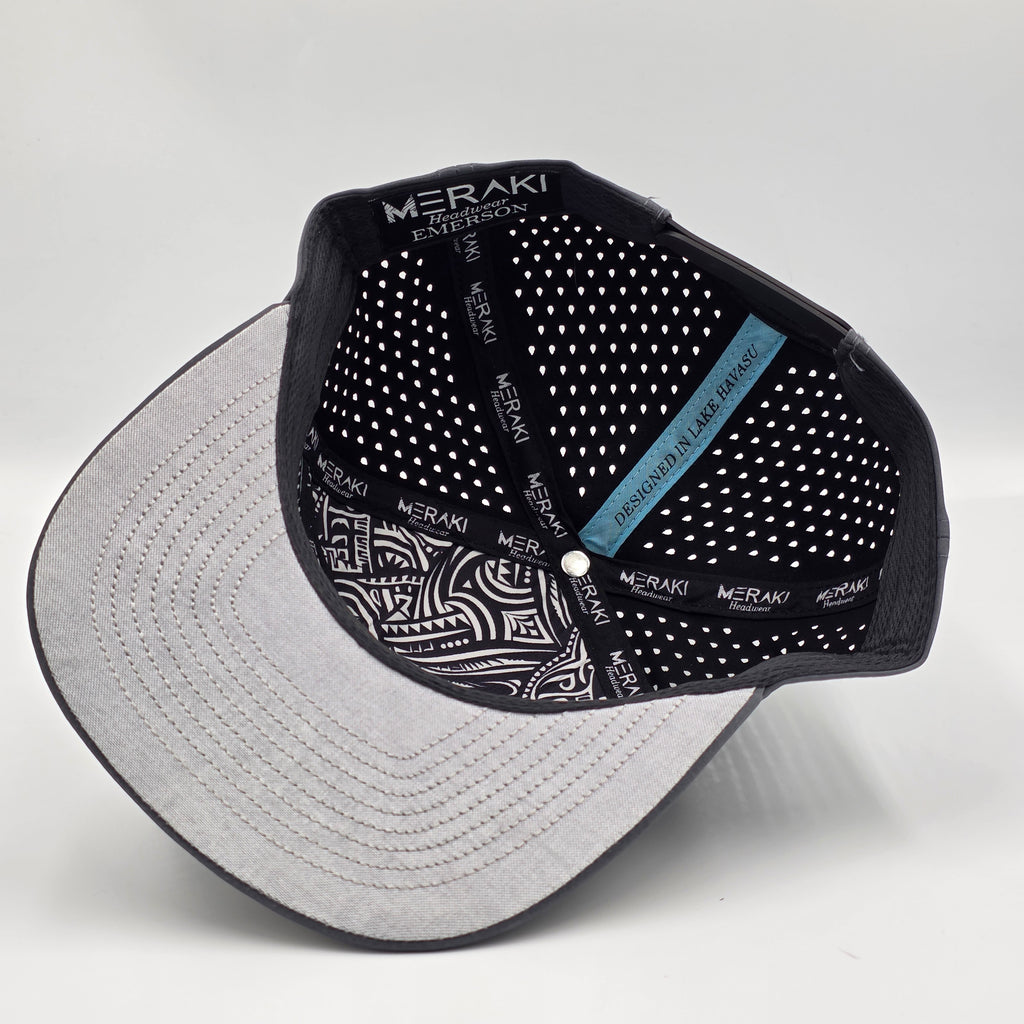 Underside of cap with 'MERAKI' branding on a light gray background variant-carbon-charcoal